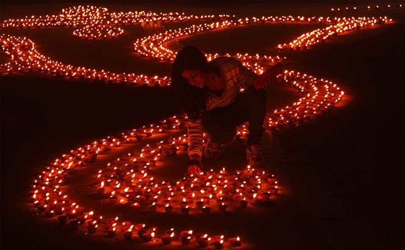 girl-lights-earthen-lamps-india